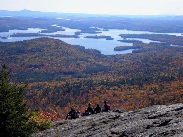 Hikers relaxing on the summit ledges of Mount Percival enjoy a bird's-eye view of nearby Squam Lake (photo by Mike Dickerman)